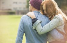 Glückliches junges Paar umarmt sich im Park — Stockfoto