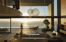 Женщина в современном доме с видом на океан — стоковое фото
