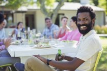 Man smiling at table outdoors — Stock Photo
