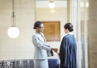 Judge and lawyer shaking hands in courthouse — Stock Photo