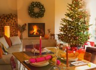 Mesa de jantar ambiente, lareira e árvore de Natal na sala de estar — Fotografia de Stock