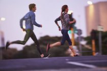 Runner couple running on urban city street — Stock Photo