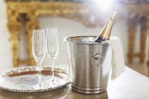 Шампанське в срібному відрі поруч з флейтами шампанського — стокове фото