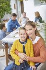 Ritratto madre e figlia godendo patio pranzo con la famiglia — Foto stock