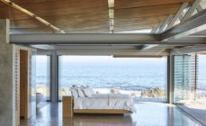 Modernes Luxusbett offen zur Terrasse mit sonnigem Meerblick — Stockfoto