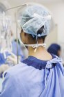 Visão traseira da cirurgiã em pé no centro cirúrgico — Fotografia de Stock