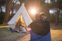 Boys wrapped in blanket at campsite — Stock Photo