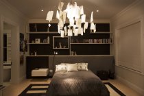 Illuminated modern paper chandelier hanging in bedroom — Stock Photo