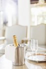 Champagne in silver bucket next to champagne flutes — Stock Photo