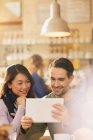 Щаслива пара використовує цифровий планшет у кафе — стокове фото