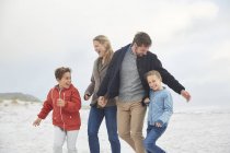 Грайлива сім'я на зимовому пляжі разом — стокове фото
