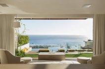 Camera da letto soleggiata e patio con vista sull'oceano — Foto stock