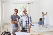 Father and son looking through construction plans — Stock Photo