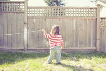 Baby girl playing with string in backyard — Stock Photo