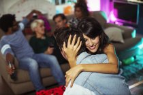 Paar umarmt sich bei Party im Wohnzimmer — Stockfoto