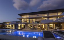Vitrine de luxe moderne éclairée extérieure avec piscine la nuit — Photo de stock