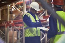 Workers with clipboards meeting in distribution warehouse — Stock Photo