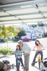 Multi-generation family riding bicycles in driveway — Stock Photo