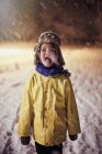 Junge in warmer Kleidung streckt Zunge heraus, schmeckt Schnee — Stockfoto