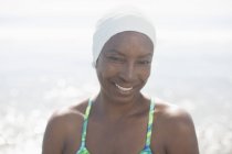 Портрет улыбающейся женщины в плавательной шапке на пляже — стоковое фото