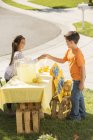 Хлопчик купує лимонад на підставці для лимонаду — стокове фото