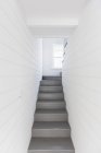 Escaliers gris entre les murs du tableau blanc — Photo de stock