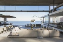 Maison moderne et luxueuse vitrine intérieure salon ouvert sur la vue sur l'océan — Photo de stock