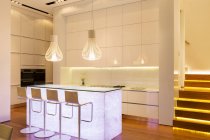 Bar bancos e iluminação na cozinha moderna — Fotografia de Stock