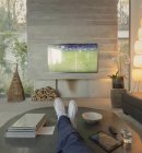 Mann aus persönlicher Perspektive schaut Fußball im Wohnzimmer im Fernsehen — Stockfoto