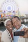 Couple de personnes âgées prenant selfie au parc d'attractions — Photo de stock