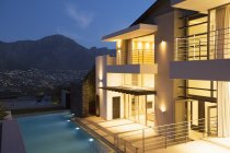 Casa moderna con piscina illuminata di notte — Foto stock