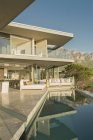 Солнечный современный витринный патио с бассейном и видом на горы — стоковое фото
