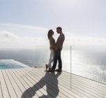 Пара на сучасному балконі з видом на океан — стокове фото