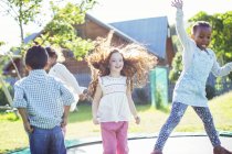 Enfants sautant sur le trampoline à l'extérieur — Photo de stock
