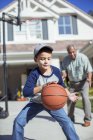 Abuelo y nieto jugando baloncesto en la entrada - foto de stock