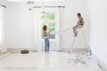 Couple laying out wallpaper together — Stock Photo