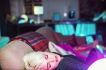 Blonde woman sleeping on sofa after party — Stock Photo