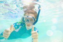 Retrato chica confiada buceando bajo el agua, haciendo gestos pulgares hacia arriba - foto de stock