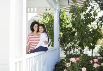 Portrait of smiling mother and daughter on porch — Stock Photo