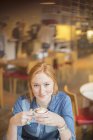 Mujer bebiendo taza de café en la cafetería - foto de stock