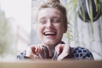 Retrato riéndose mujer joven con auriculares - foto de stock