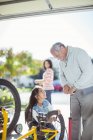 Grandfather and granddaughter inflating bicycle tire — Stock Photo