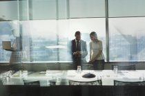 Homme d'affaires et femme d'affaires travaillant, en utilisant une tablette numérique dans la salle de conférence urbaine — Photo de stock