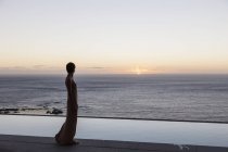 Женщина смотрит на океан из внутреннего дворика — стоковое фото
