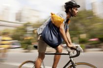 Человек на велосипеде по улице города — стоковое фото