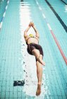 Mergulho de nadador na água da piscina — Fotografia de Stock