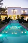 Lap pool and Spanish villa at dusk — Stock Photo