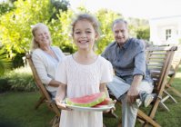 Girl holding plate of watermelon fruit outdoors — Stock Photo