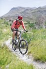 Білий дорослий гірський велосипедист на ґрунтовій доріжці — стокове фото