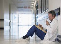 Doctor using dictaphone in hospital corridor — Stock Photo